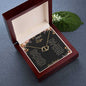 A 10k gold Everlasting Love Necklace in a mahogany box with a to wife greeting card turned sideways