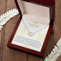 A everlasting love necklace in a mahogany box on a woodgrain table.
