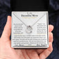 a lucky in love necklace up close in a models hand