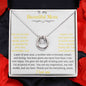 A lucky in love necklace in a two-tone box with rose petals
