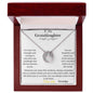 A white gold lucky in love necklace up close in a mahogany box