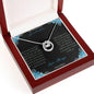 Lucky In Love Necklace with a white gold charm on a to granddaughter from grandpa greeting card in a mahogany box angled to the right