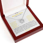 A lucky in love necklace in a mahogany box angled left