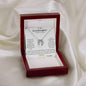 A white gold lucky in love necklace up close on a white cloth