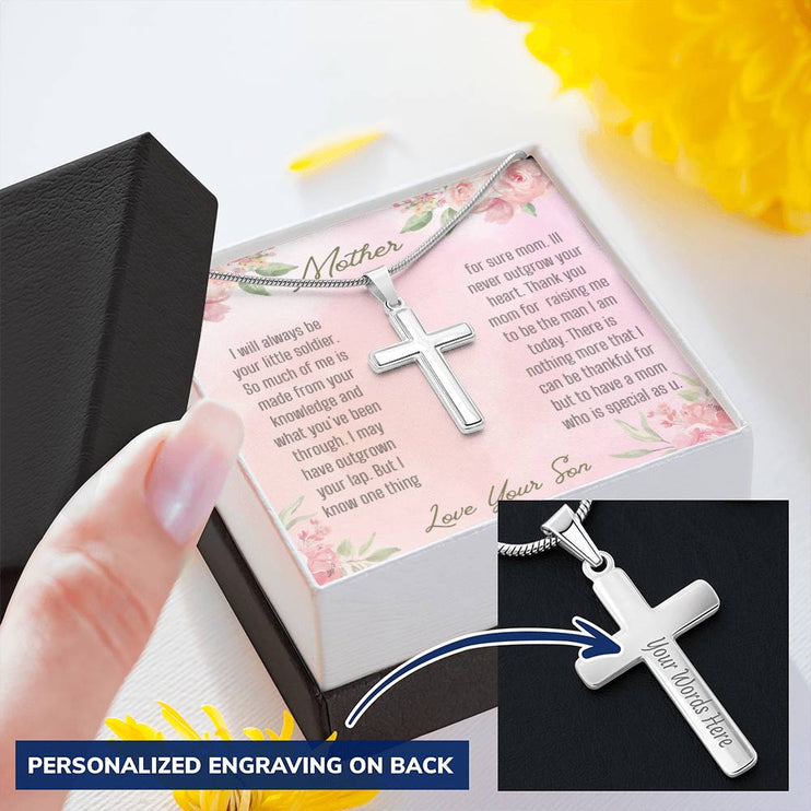 A personalized cross necklace in a two-tone box angled to the left showing engraving feature.