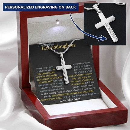 a cross pendant necklace in a mahogany box on a white cloth