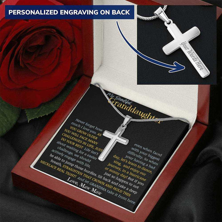 a cross pendant necklace in a mahogany box angled to right with red rose