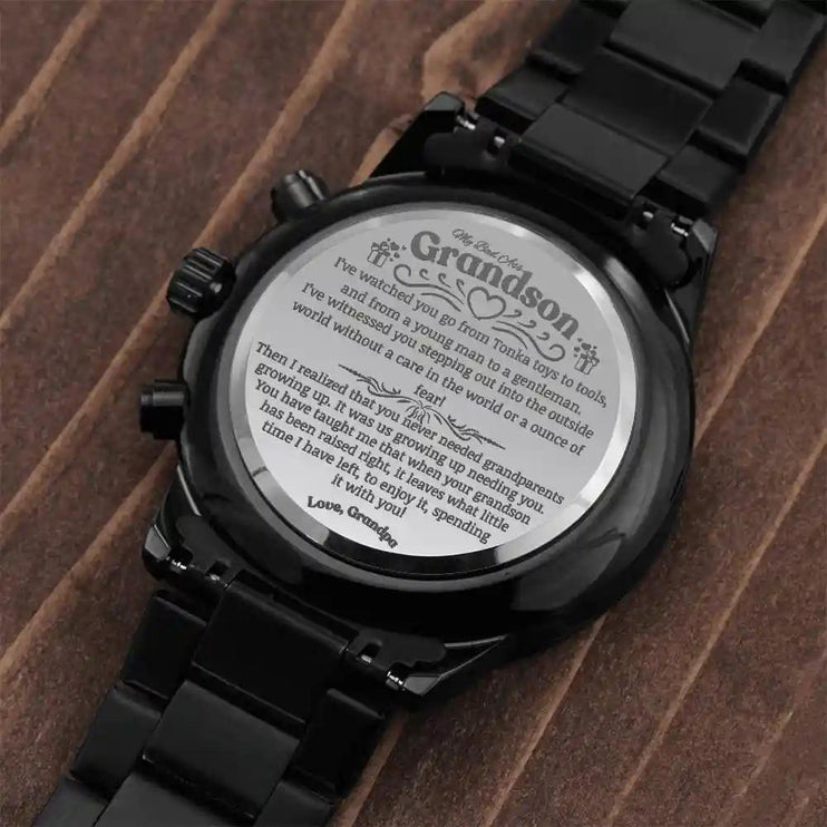 a black chronograph watch showing the message on a table.