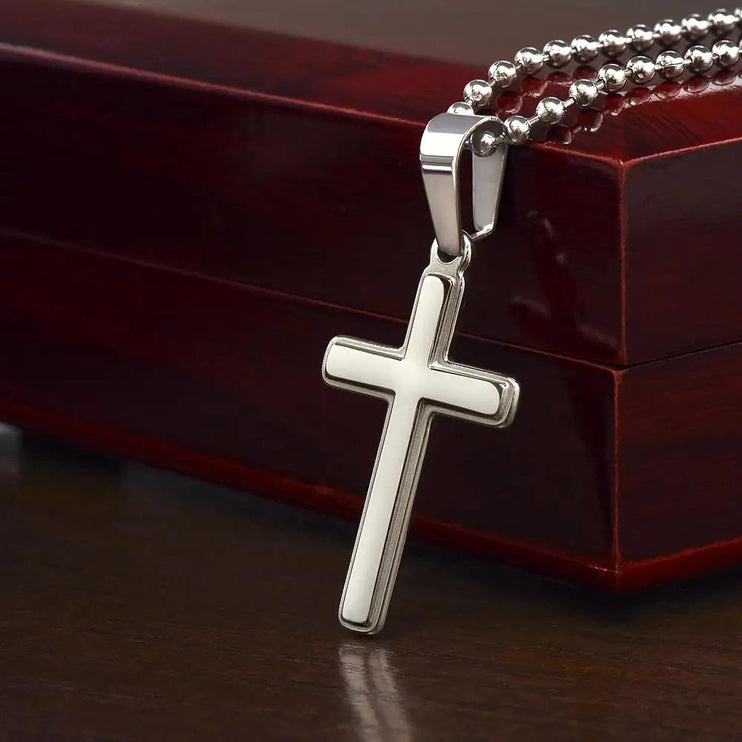 cross on ball chain necklace on closed mahogany box