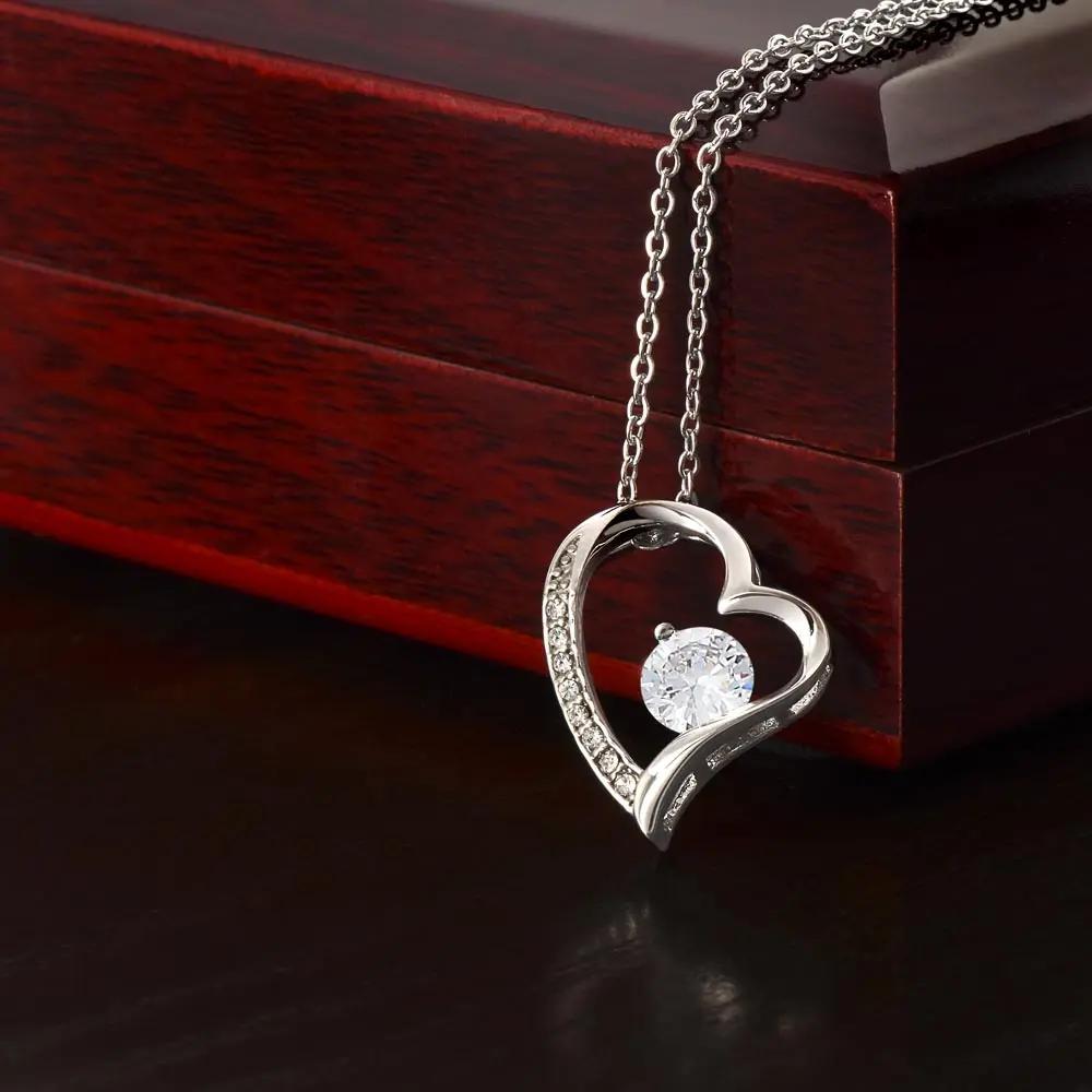 white gold forever love necklace on top of a mahogany box