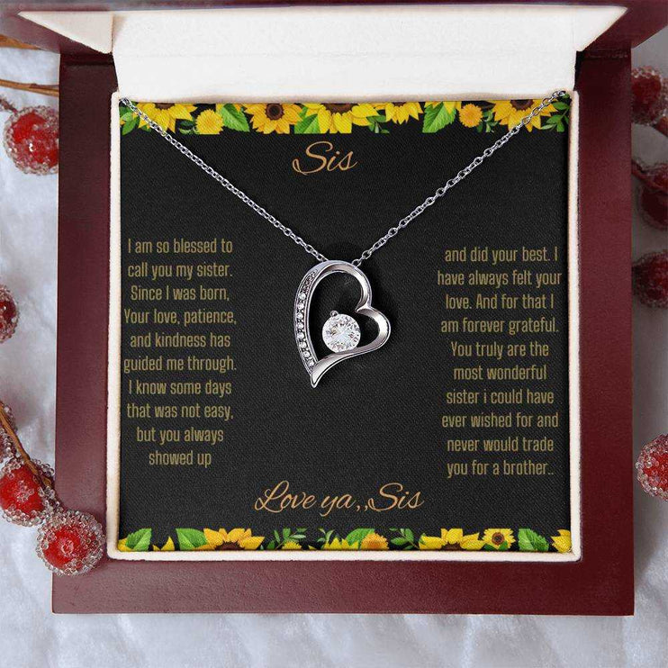 Forever Love Necklace with a white gold charm on a To Sis from Sis greeting card up close in a mahogany box