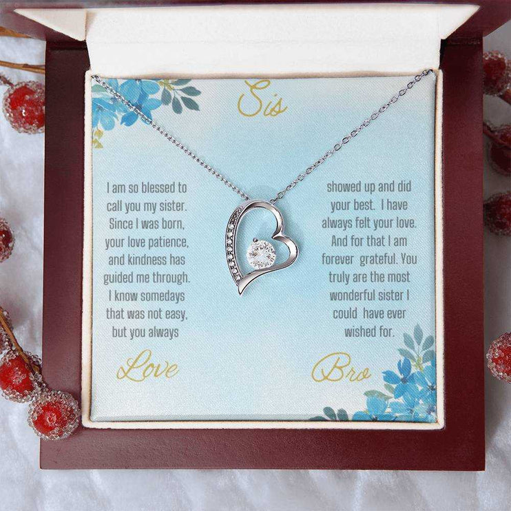 Forever Love Necklace with a white gold variant on a to sis from bro greeting card close up view in a mahogany box.