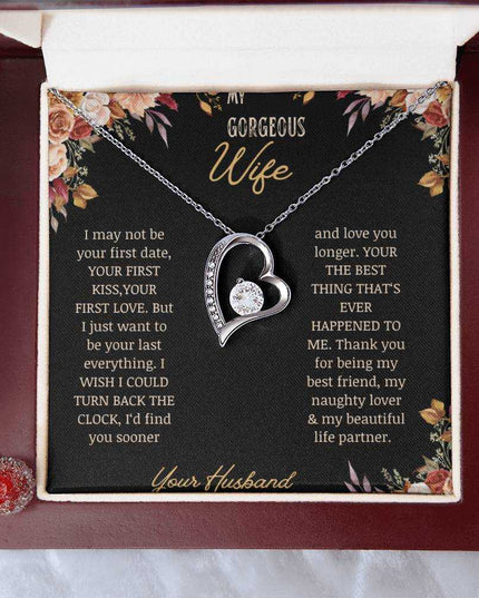A white gold Forever Love Necklace on a to wife greeting card in a mahogany box on a table.