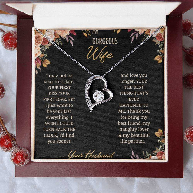 A white gold Forever Love Necklace on a to wife greeting card in a mahogany box on a table.