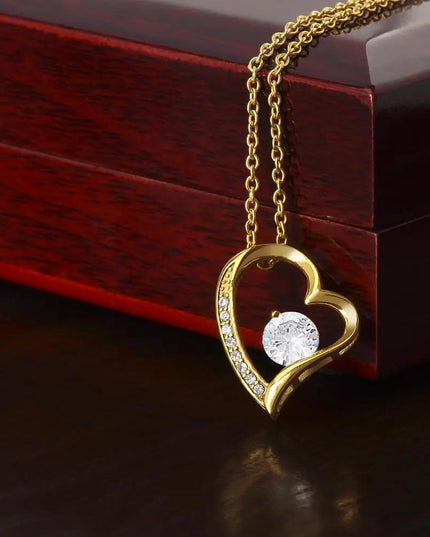 yellow gold forever love necklace on top of a mahogany box
