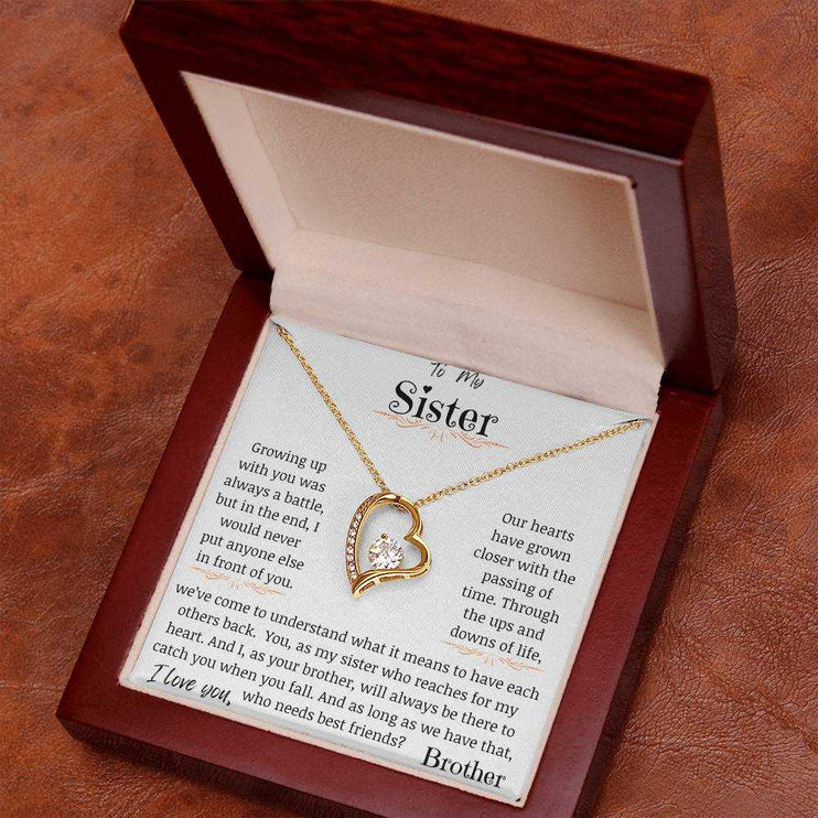 a yellow gold forever love necklace angled to right on table .