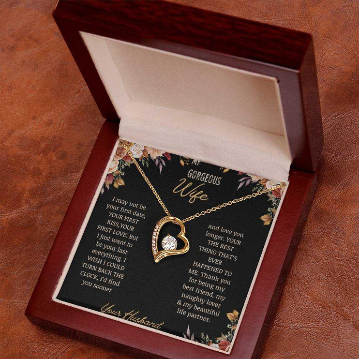 A yellow gold Forever Love Necklace on a to wife greeting card in a mahogany box on a table.