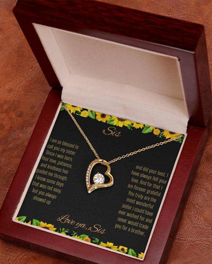 Forever Love Necklace with a yellow gold charm on a To Sis from Sis greeting card up close angled slightly to right in a mahogany box 