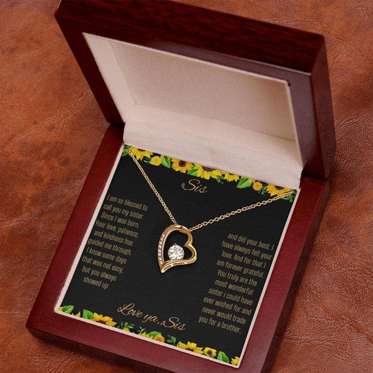 Forever Love Necklace with a yellow gold charm on a To Sis from Sis greeting card up close angled slightly to right in a mahogany box 