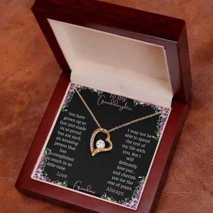 Forever Love Necklace with a yellow gold charm on a for granddaughter from grandpa greeting card in a mahogany box angled to the left 