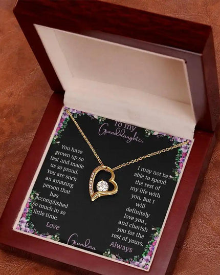 Forever Love Necklace with a yellow gold charm on a for granddaughter from grandpa greeting card in a mahogany box angled to the left 