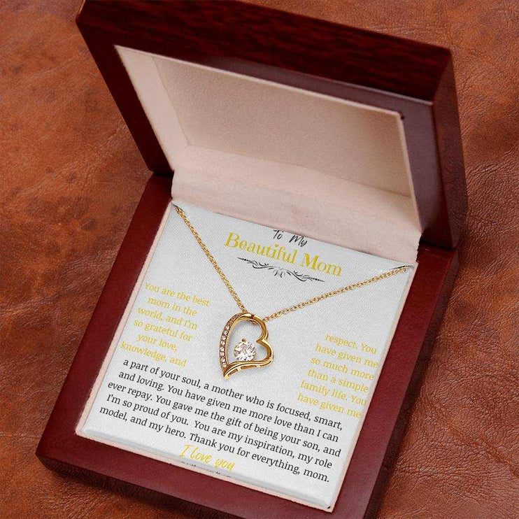 A yellow gold forever love necklace in a mahogany box angled to right