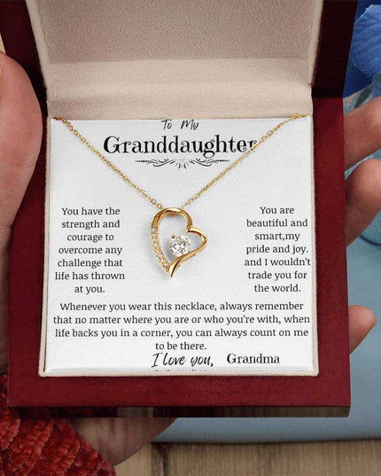 a yellow gold forever love necklace in a mahogany box up close.