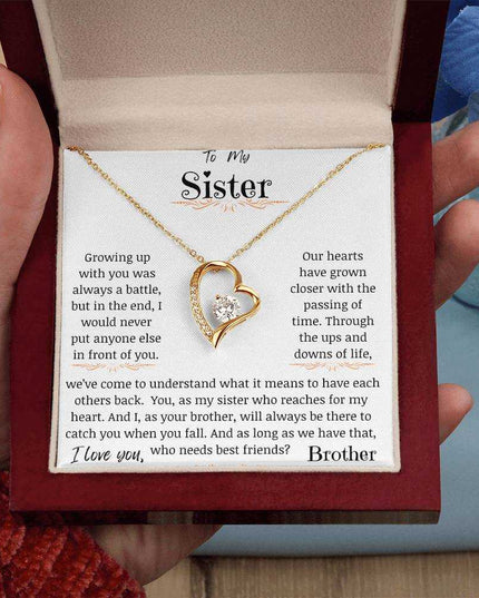 a yellow gold forever love necklace in a models hand.