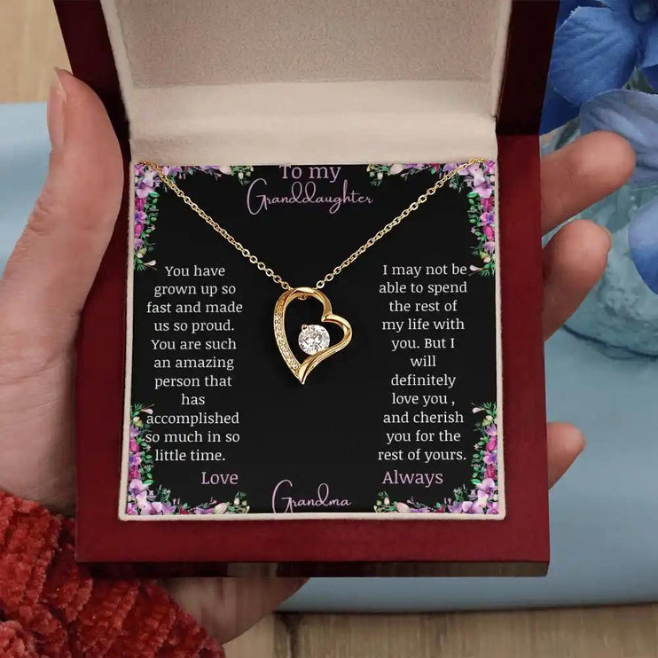 Forever Love Necklace with a yellow gold charm on a for granddaughter from grandpa greeting card in a mahogany box in a models hand