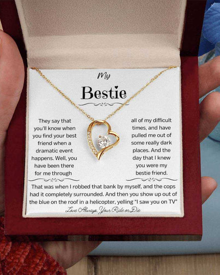 a yellow gold forever love necklace in a mahogany box in a hand