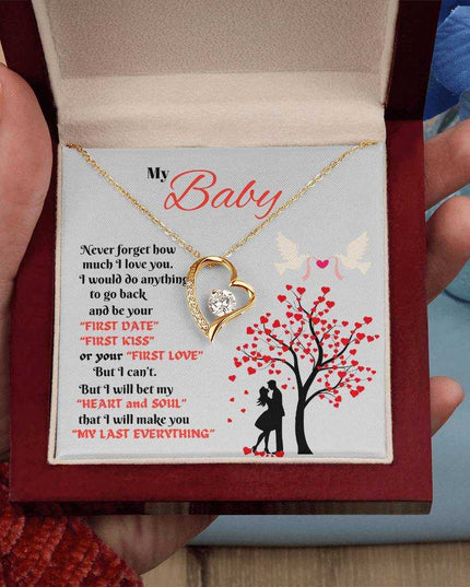 yellow gold forever love necklace in a luxury box in a model's hand