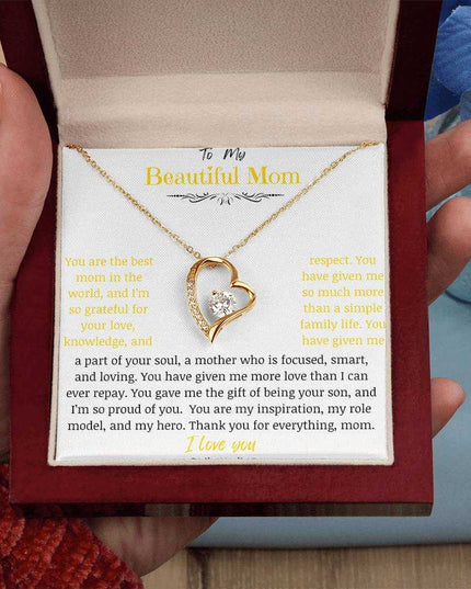 A yellow gold forever love necklace in a mahogany box in a models hand