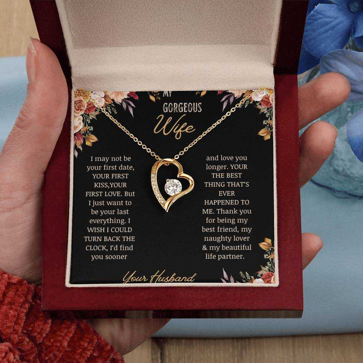 A yellow gold Forever Love Necklace on a to wife greeting card in a mahogany box in a models hand.