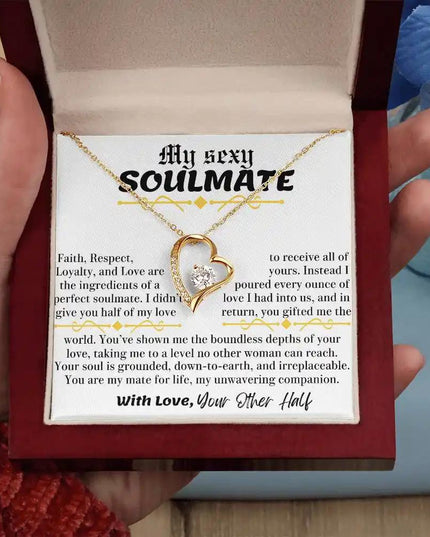 a yellow gold forever love necklace up close in a mahogany