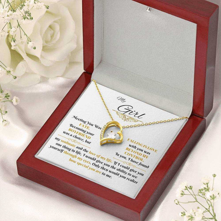 gold forever love necklace in a luxury box angled to the left with flowers