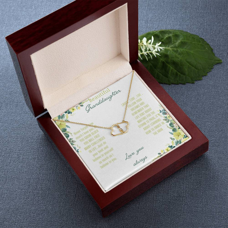 a everlasting love necklace in a mahogany box on a table angled left