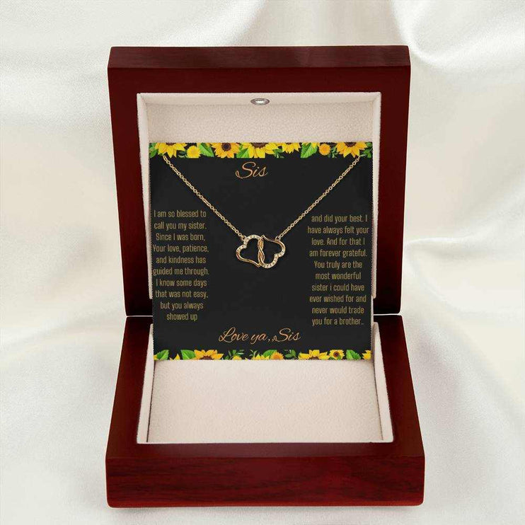 Everlasting Love Necklace with a to sis from sis greeting card inside a mahogany box sitting on a table with a white drop cloth
