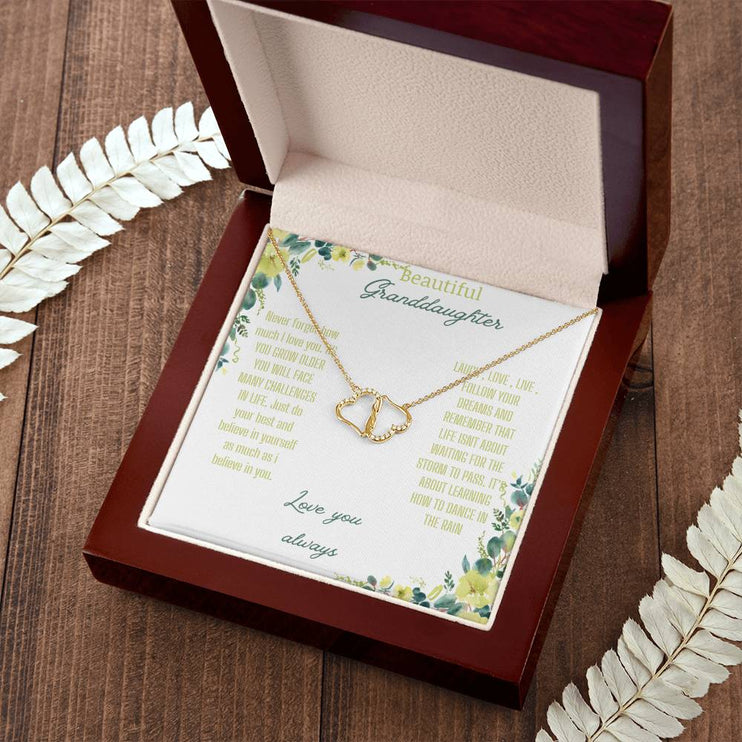 a everlasting love necklace in a mahogany box on a woodgrain table with flower