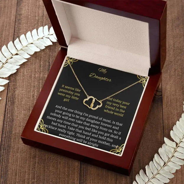Everlasting Love Necklace in a mahogany box with a to daughter from mother greeting card with angle tilted left further away