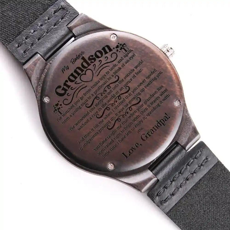 A engraved wooden watch face down showing message on back.