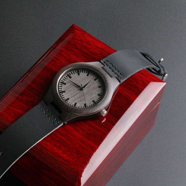 wooden watch engraved on top of a closed luxury box