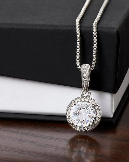 white gold eternal hope necklace on top of a two-tone box