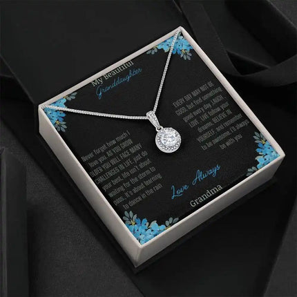 Eternal Hope Necklace with a to granddaughter from grandpa greeting card in a two-tone box on a black backdrop angled to the right