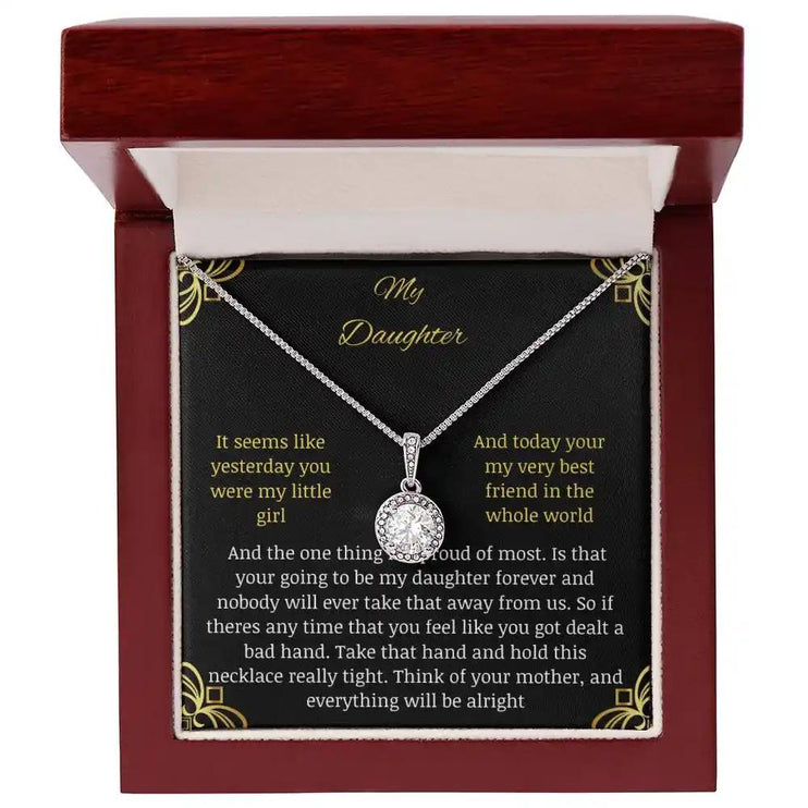 Eternal Hope Necklace in a mahogany box with a to daughter from mom greeting card looking straight down on white background