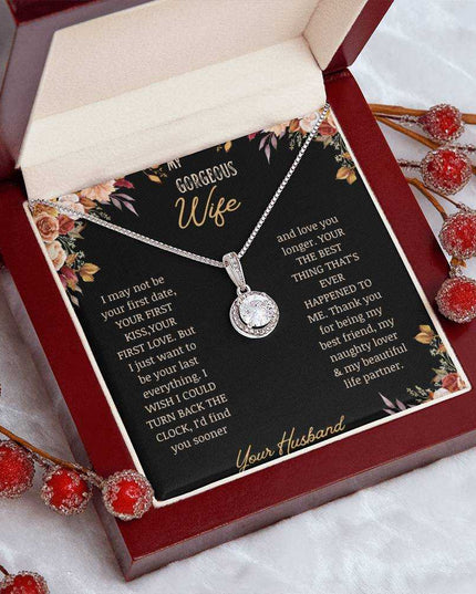 A white gold Eternal Hope Necklace on a to wife greeting card in a mahogany box on a coffee filter with red flower buds