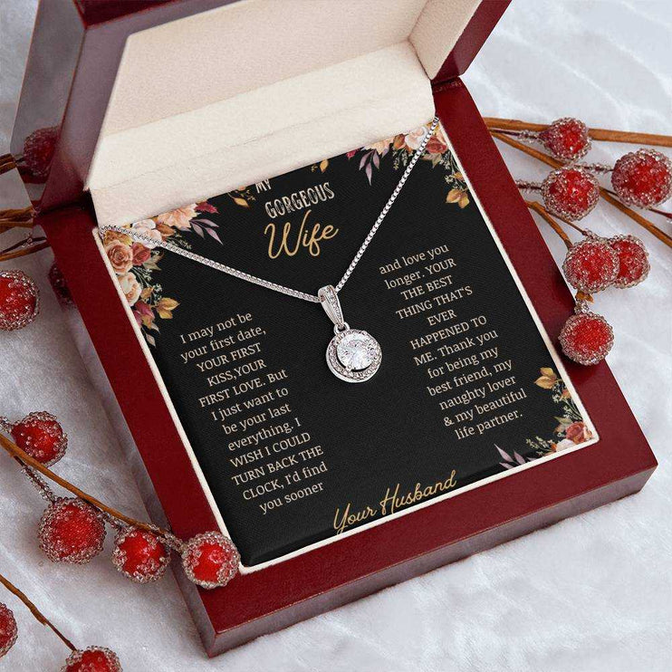 A white gold Eternal Hope Necklace on a to wife greeting card in a mahogany box on a coffee filter with red flower buds
