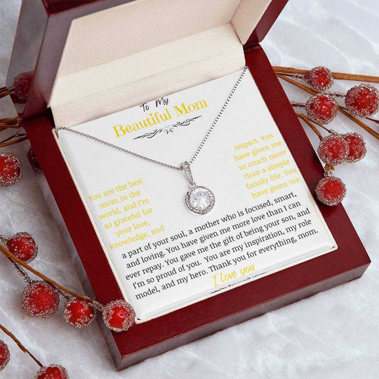 A white gold eternal hope necklace close up in a mahogany box on a coffee filter with red flower buds