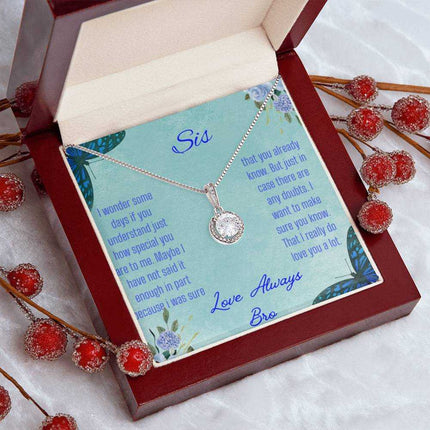 Eternal Hope Necklace on a To Sis from Bro greeting card in a mahogany box on a white coffee filter angled to the left with red bud flower stems