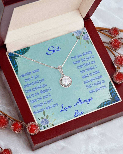 Eternal Hope Necklace on a To Sis from Bro greeting card in a mahogany box on a white coffee filter angled to the left with red bud flower stems