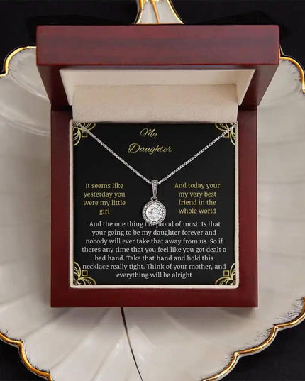 Eternal Hope Necklace in a mahogany box with a to daughter from mom greeting card sitting on a coffee filter looking straight down